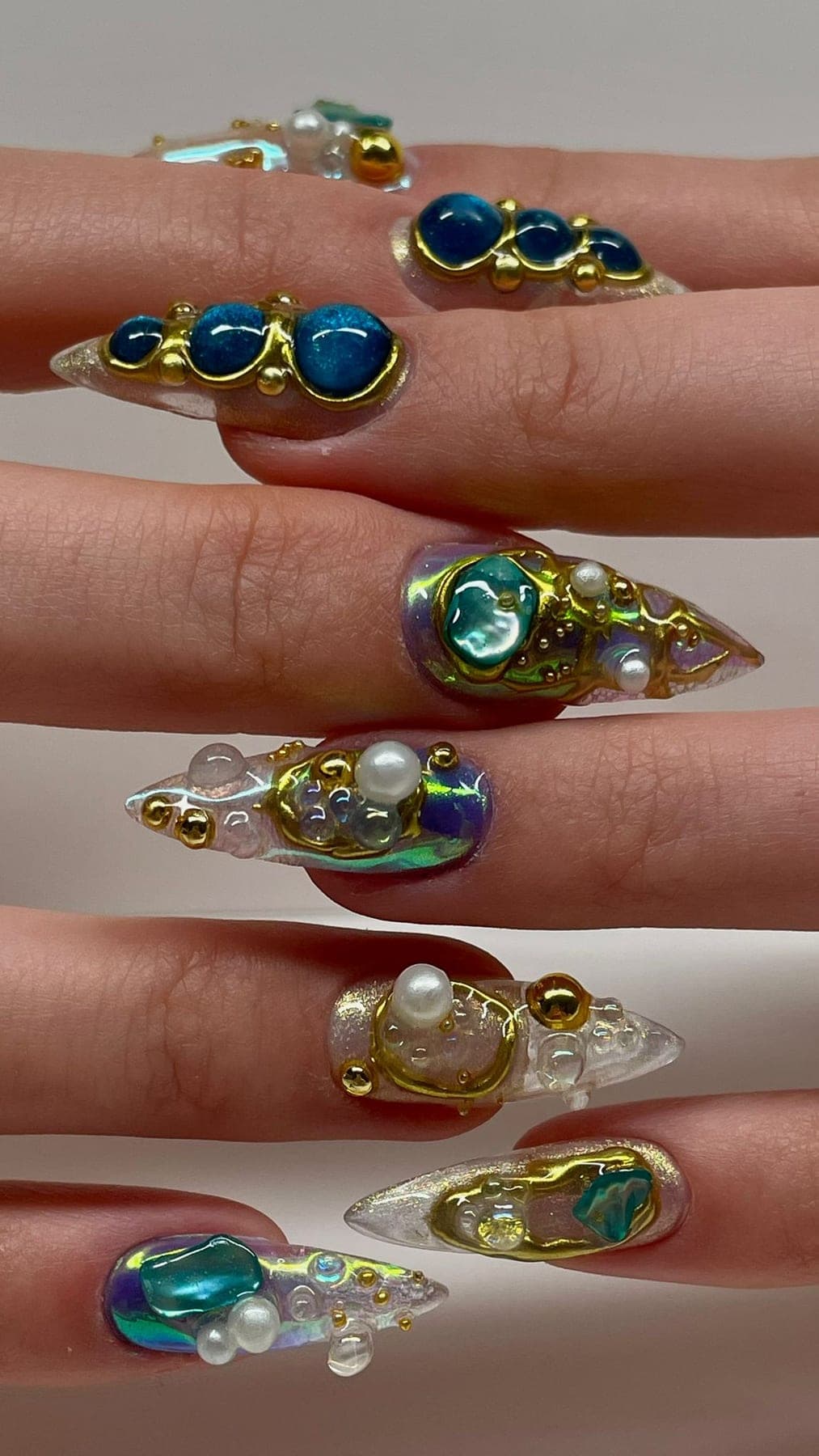 Extra-long bleu et nude, perles, strass et bijoux dorés très présents.