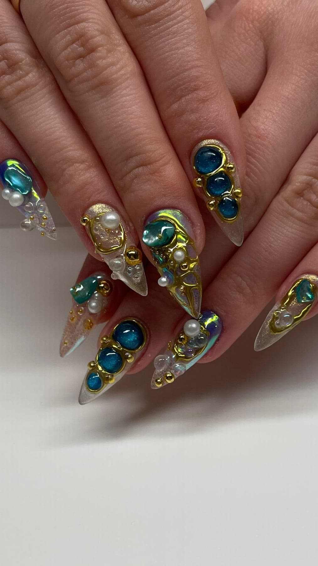 Stiletto nude avec strass bleus, perles et ornements dorés en relief.
