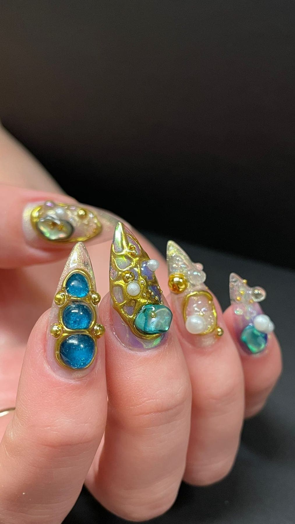 Pointes dorées ornées de strass bleus, perles et bijoux 3D.