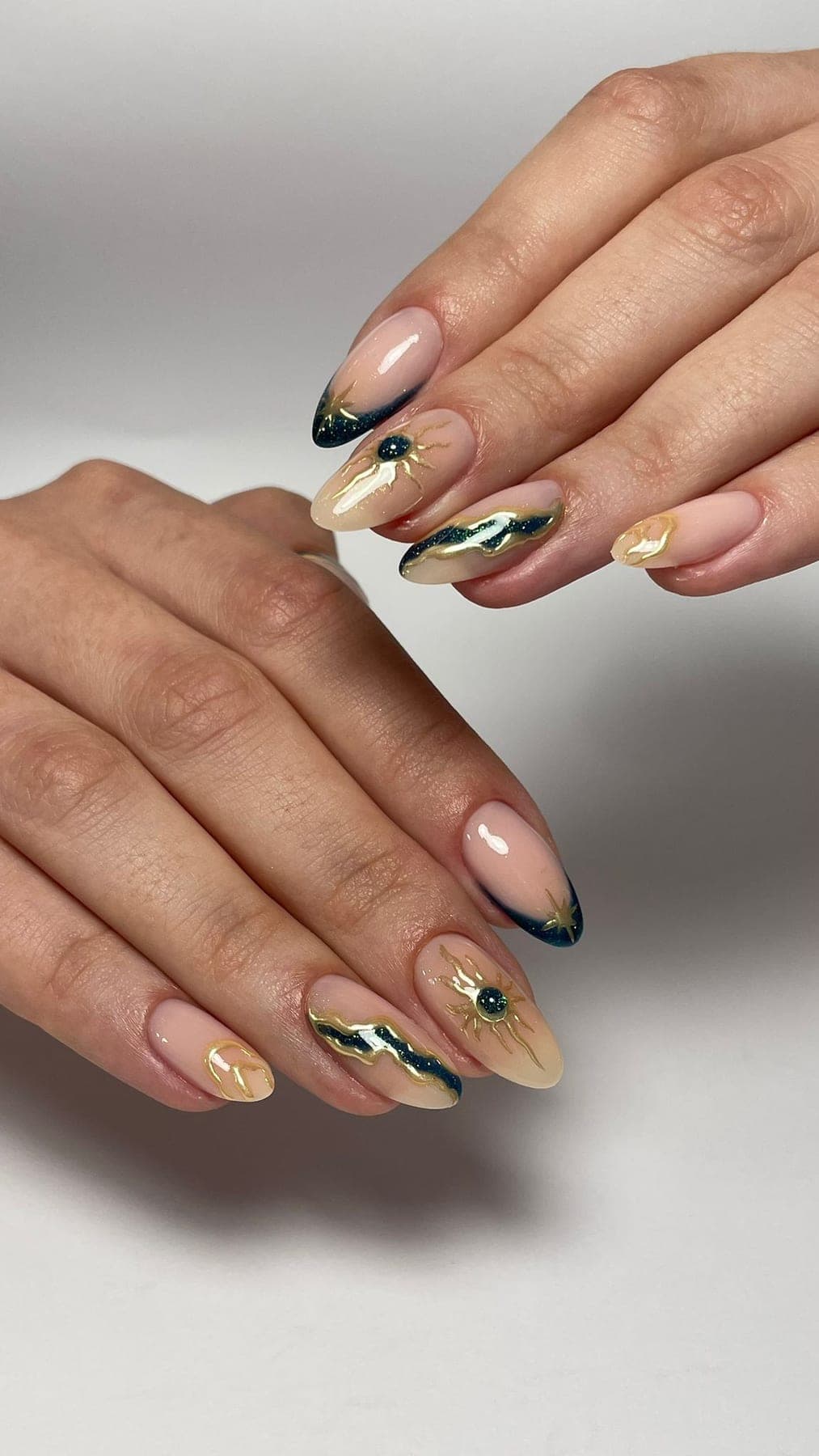 Nude rosé allongé avec accents or, noir et strass discrets.