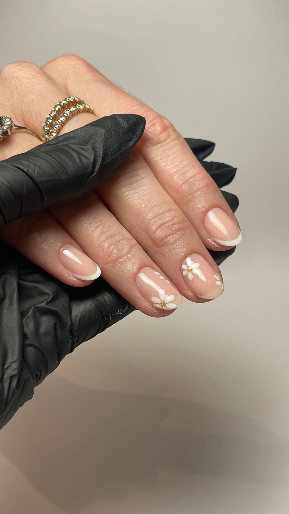 French nude avec petites fleurs blanches et touches dorées délicates.